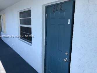View of a building entrance with a blue door and adjacent window.