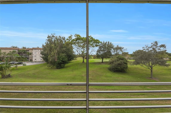 View of a grassy area with trees from a balcony or window.