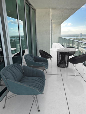 Balcony with modern furniture overlooking surrounding cityscape