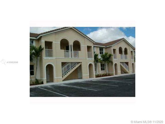 Front view of a multi-story residential building with arches and staircases.