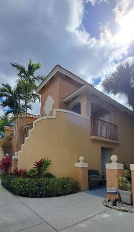 Front view of a two-story building with a decorative facade and balcony.