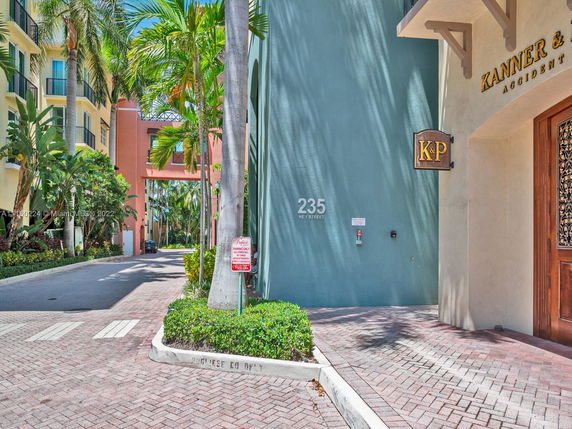 Front corner view of a multi-story building with colorful facade and prominent signage near the entrance.