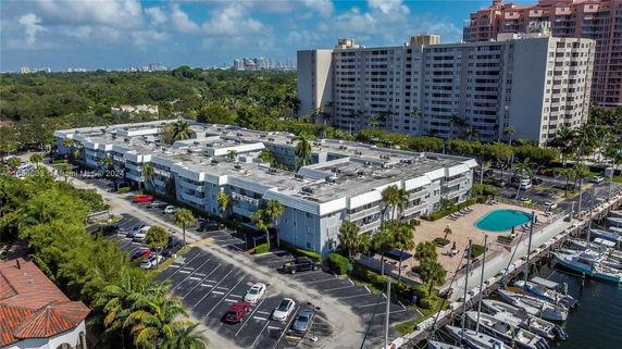 Aerial view of a residential complex with adjacent parking and a swimming pool.