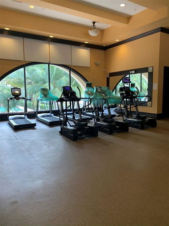 Indoor gym area with exercise machines and large window.