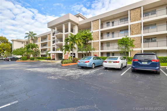Front view of a multi-story building with a parking area in front.