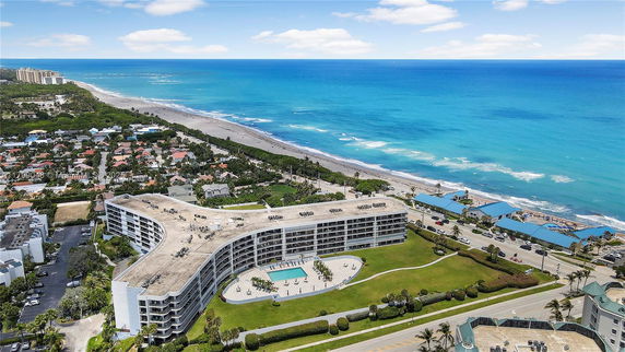 Panoramic view of a coastal area with a large, multi-story building near the beach.