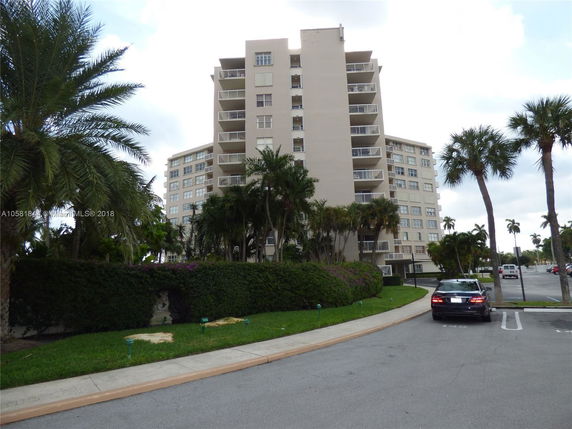 Front view of a multi-story apartment building with balconies.
