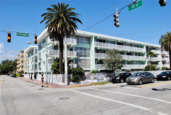 Front view of a multi-story apartment building with balconies.