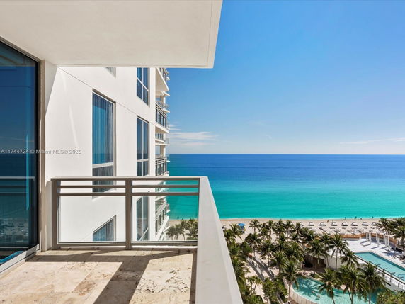 Balcony view of a beachfront building with ocean in the background.