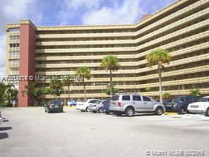 Front view of a multi-story residential building with a parking lot.