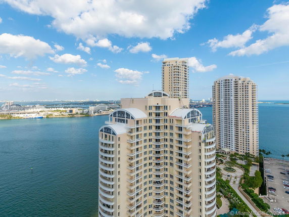 High-rise buildings near a body of water, with a view of the city skyline in the background.