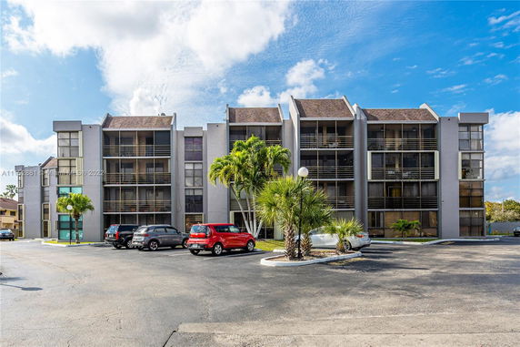 Front view of a multi-story apartment building with balconies.