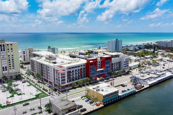 Aerial view of a coastal area with a large building complex near the beach and ocean.