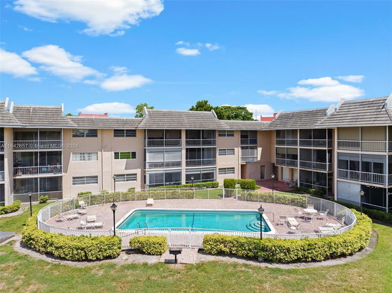 Outdoor swimming pool area surrounded by residential buildings.