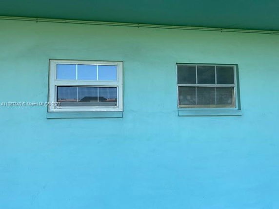 Front view of a building wall with two windows.
