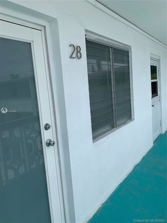 Front view of a building with a door and window, labeled number 28.