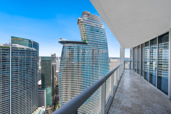 Panoramic view from a high-rise balcony overlooking modern skyscrapers.