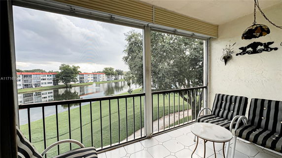 Balcony view of a pond and nearby residential buildings.