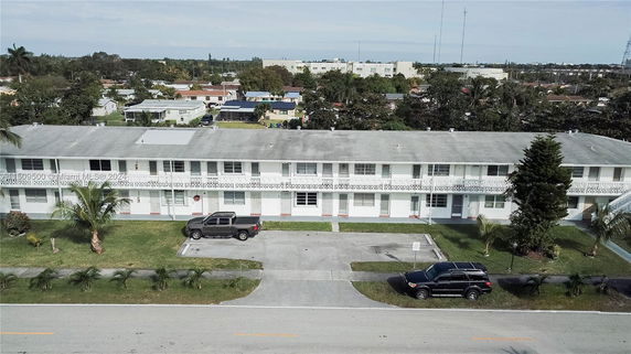 Front view of a two-story apartment building with parking spaces.