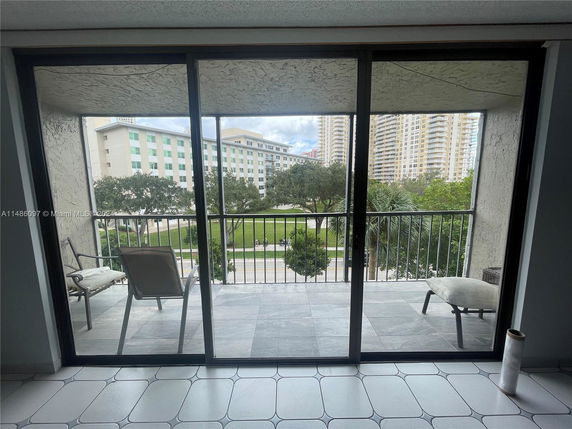 View from a balcony overlooking a park and multiple high-rise buildings.