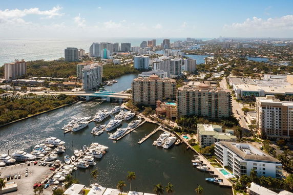 Aerial view of a marina surrounded by multi-story residential buildings and waterways.
