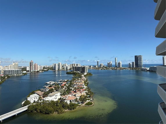 Panoramic view of a waterfront cityscape with high-rise buildings and a waterway.