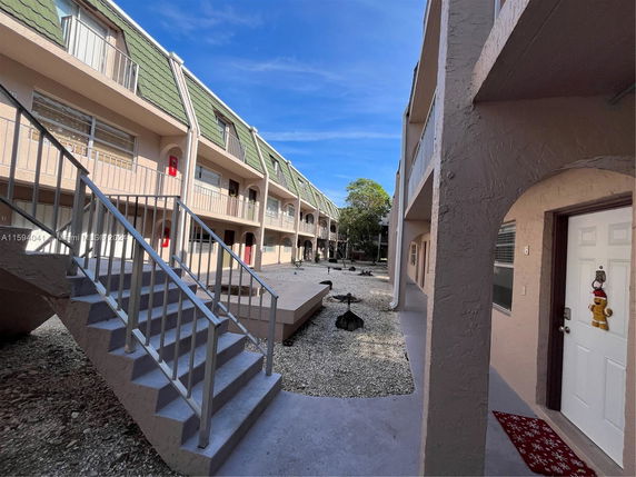 View of multi-story apartment complex with external staircases and balconies.