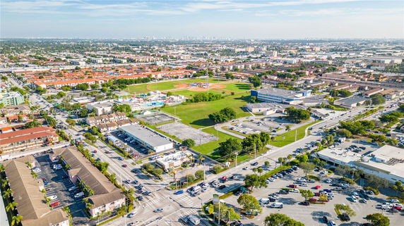 Aerial panoramic view of an urban area with a baseball field and surrounding buildings.