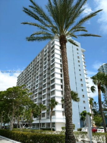 Front view of a multi-story residential building with balconies.