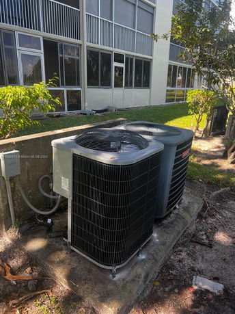 Front view of a multi-story building with visible air conditioning units outside.