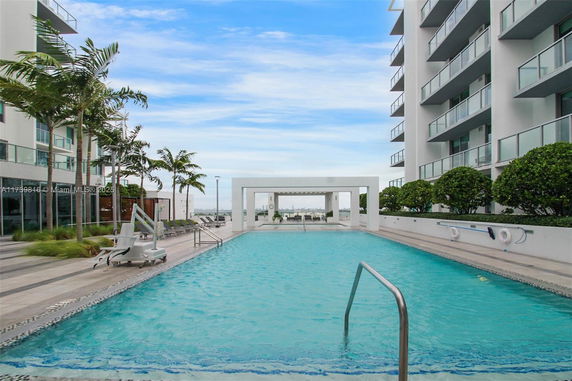 Outdoor swimming pool area with lounge chairs and greenery
