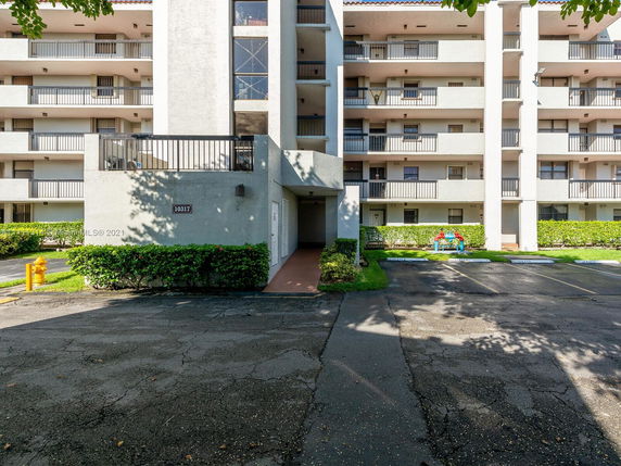 Front view of a multi-story apartment building with balconies.