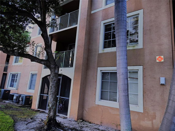 Front view of a multi-story residential building with balconies and windows.