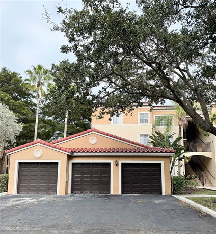 Front view of a house with a three-car garage and tile roof.