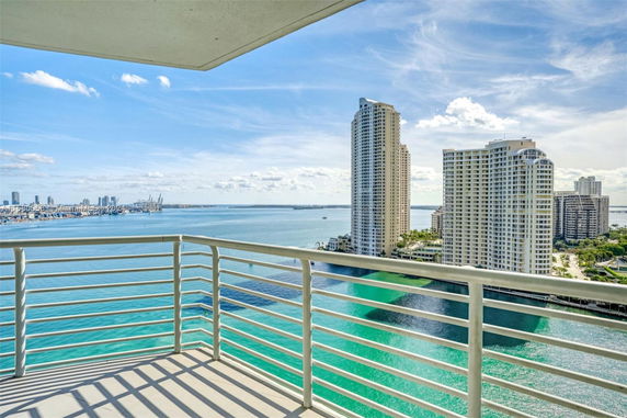 Panoramic view from a balcony showing high-rise buildings and a waterfront.