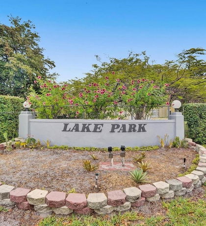 Entrance sign for Lake Park surrounded by plants and trees.