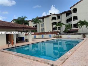 Swimming pool area in front of a multi-story residential building.