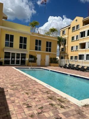 Outdoor swimming pool area adjacent to a multi-story building.