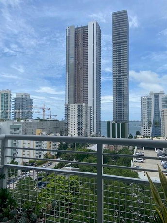 View of tall buildings from a balcony in an urban area.