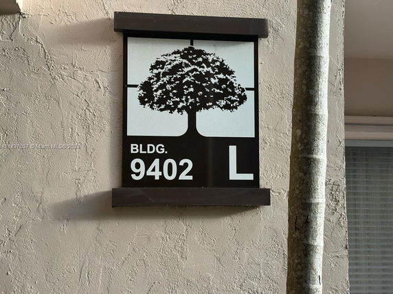 Building sign with the number 9402 and letter L on the wall.