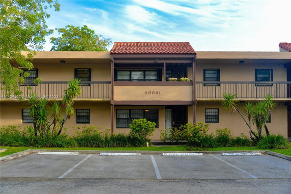 Front view of a two-story building with balconies and a tiled roof.