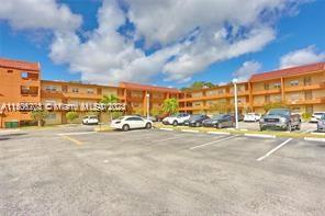 Outdoor parking area in front of a three-story residential building.