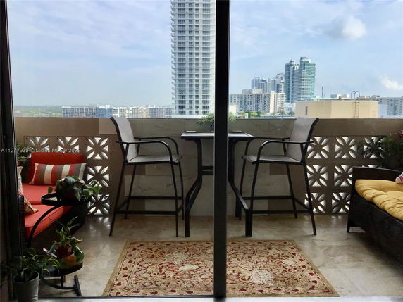 View from a balcony overlooking high-rise buildings in a cityscape.