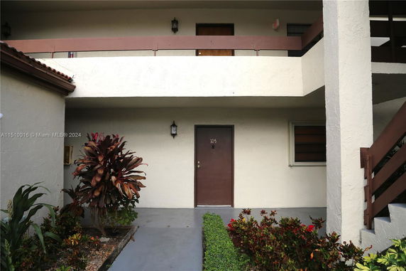 Front view of a building with two levels and a single door on the ground floor.