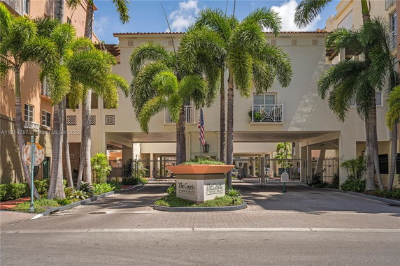 Front view of a multi-story residential building with a gated entrance.