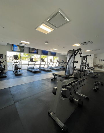 Indoor gym with treadmills and weightlifting equipment.