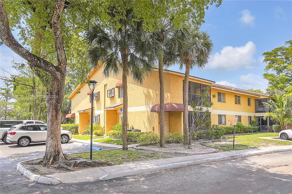Front view of a two-story yellow apartment building.
