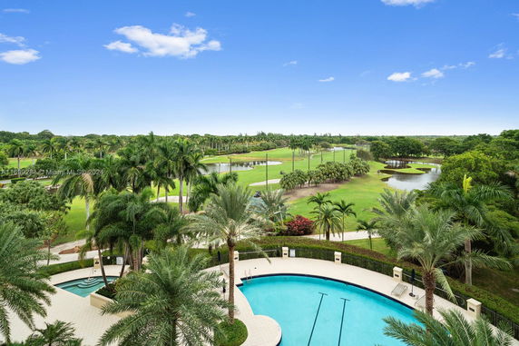 Wide angle view of a swimming pool and surrounding greenery.