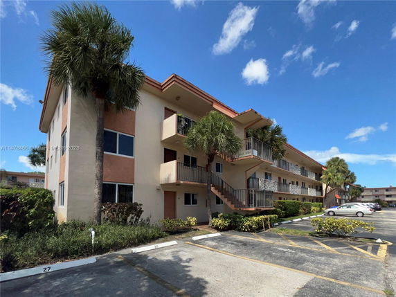 Front view of a three-story apartment building with balconies.