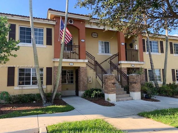 Front view of a two-story residential building with stairs and balconies.
